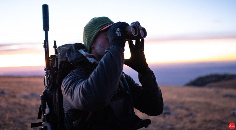 man using rangefinding binoculars